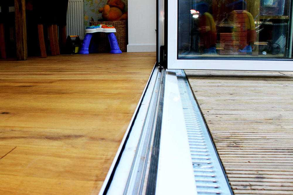 internal level threshold for a bi-fold door with a white cill with a gully drain to the front